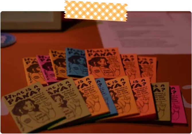 Copies of the “What Is a Pana?” zine fanned out on a table